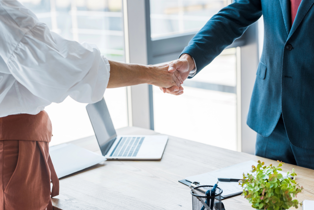 Cropped view of employee and recruiter shaking hands in office Cropped view of employee and recruiter shaking hands in office